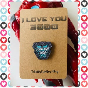 Spilla smaltata con la scritta "Ti amo 3000"