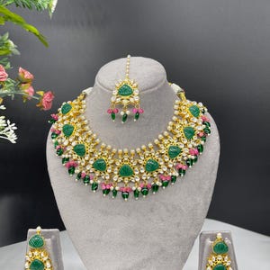 Zestaw naszyjnika-choker inspirowany Tyaani Sabyasacchi z zielonymi rzeźbionymi kamieniami, koralikami z różowego rubinu kundan, kolczykami matha teeka i zestawem Bollywood.