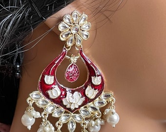 May include: Red and white enamel earrings with a floral design and pearl accents.