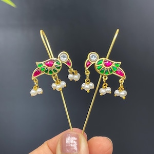 May include: A pair of gold earrings with a bird design. The birds are decorated with green, red, and white enamel and have pearl drop accents.