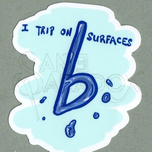 May include: A blue sticker with a white cloud shape and the text "I trip on surfaces" with a blue letter "b" dripping from the top of the cloud.