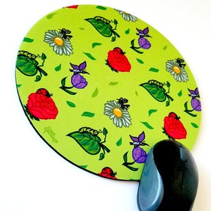 Puede incluir: Una alfombrilla de ratón redonda de color verde con un patrón repetido de rosas rojas, mariquitas, orugas y margaritas blancas. La alfombrilla de ratón tiene un borde negro y el texto "Sandpiper" en blanco.
