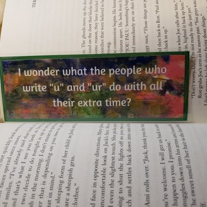 May include: A green bookmark with a colorful abstract design and the text "I wonder what the people who write "u" and "ur" do with all their extra time?"