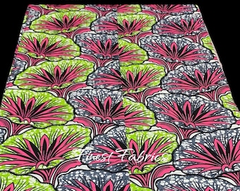 May include: A vibrant fabric with a repeating pattern of pink, green, and gray stylized flowers. The background is white with small white dots.