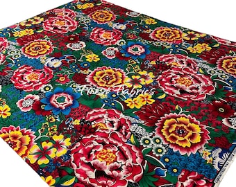 Op de afbeelding: Een levendige bloemenstof met een kleurenschema van rood, groen, geel en blauw. De stof heeft een grootschalig bloemenpatroon met een verscheidenheid aan bloemen, waaronder pioenen, rozen en madeliefjes. De stof is bedrukt met een wasblokdruktechniek, wat hem een unieke en textuurrijke uitstraling geeft. De stof is gegarandeerd wasblokdruk.