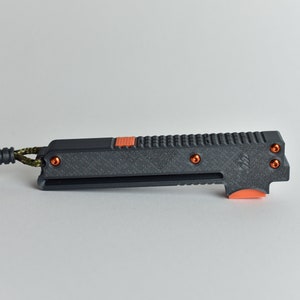 May include: A black and orange pocket knife with a textured handle and a lanyard loop. The knife has a small orange button on the side and four orange screws.