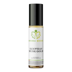 Puede incluir: Un frasco cilíndrico de vidrio con aplicador de bola que contiene un líquido dorado. La etiqueta blanca muestra un logotipo de mariposa verde, el texto AROMA SHORE, EGYPTIAN MUSK GOLD y un pequeño texto legal. Tiene una tapa cilíndrica negra.