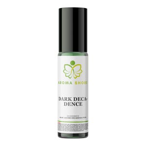 May include: A cylindrical glass roll-on bottle with a black cap containing a green liquid. The white label features a green butterfly logo, the text AROMA SHORE, DARK DECADENCE, and the phrase OUR IMPRESSION OF MARC JACOBS DECADENCE TYPE.