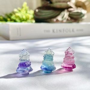 May include: Three small glass Christmas tree ornaments in shades of blue, purple, and pink. The ornaments are clear glass with a gradient of color from the top to the bottom.