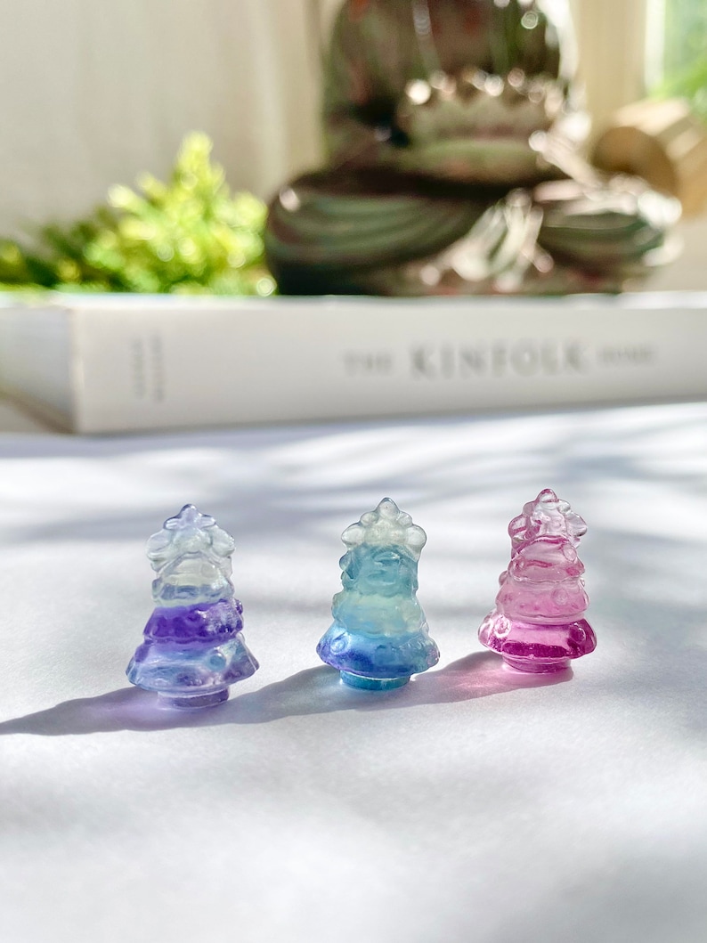 May include: Three small glass Christmas tree ornaments in shades of blue, purple, and pink. The ornaments are clear glass with a gradient of color from the top to the bottom.