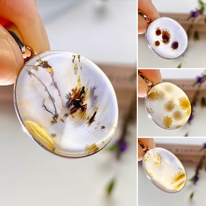 May include: Three silver pendants with different agate slices. Each pendant features a unique pattern of brown, white, and yellow agate.