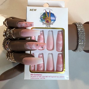 May include: Pink and white ombre press-on nails with a cloud and star design. The kit includes 24 nails, glue, a cuticle pusher, and a mini file.  NET WT 2g (0.07 oz.)