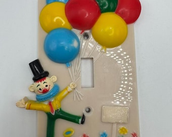 Placa de cubierta de interruptor de luz de payaso de The Dolly Toy Company, plástico, 1973