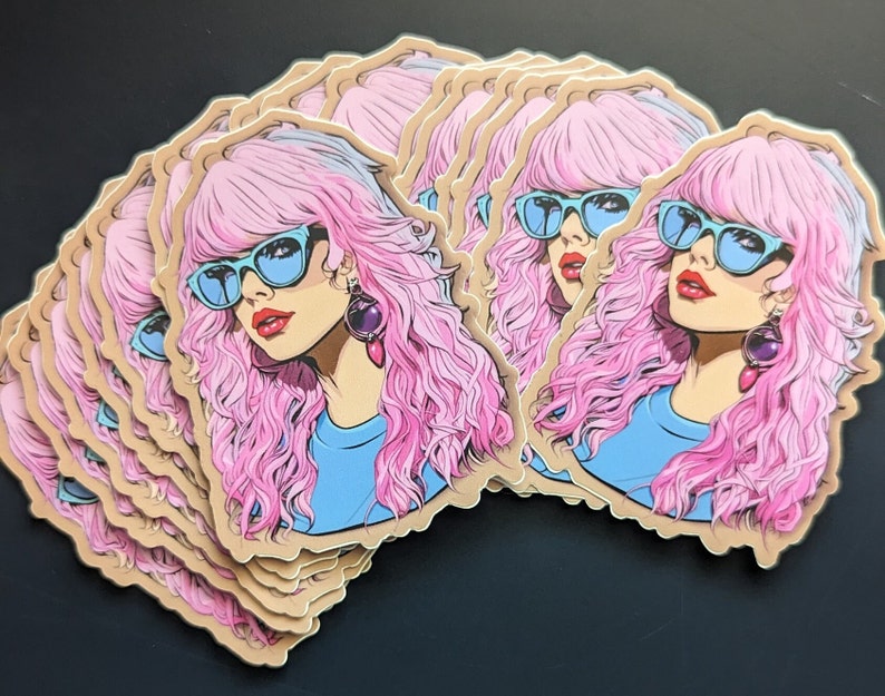 May include: A stack of stickers featuring a cartoon illustration of a woman with pink hair, blue sunglasses, and a blue shirt. The woman is wearing large, purple earrings.