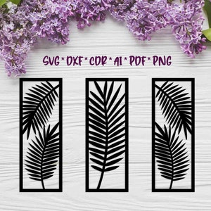 以下が含まれることがあります： 白い木製の背景に、長方形の枠の中に黒いシルエットのヤシの葉のデザインが3つあります。  SVG * DXF * CDR * AI * PDF * PNG