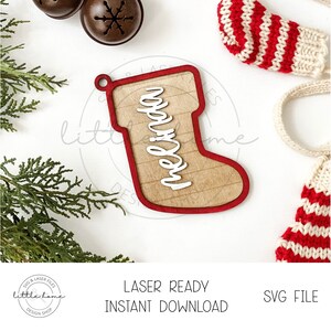 May include: A red and white striped stocking ornament with the name "Melinda" written on it. The ornament is made of wood and has a laser-cut design.