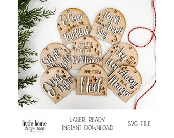May include: Set of eight laser-cut wooden Christmas ornament tags with various Christmas-themed phrases, including "O Come All Ye Faithful", "Hark! The Herald Angels Sing", "Silent Night", "Holy Night", "Little Town of Bethlehem", "Joy to the World", "The First Noel", and "Away in a Manger".
