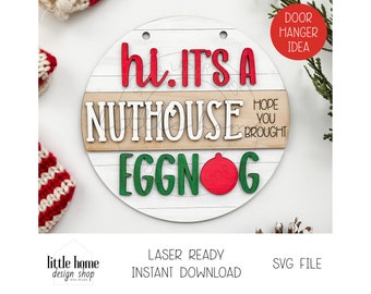 May include: A round wooden sign with a white background and a red and green design. The sign says "hi. IT'S A NUTHOUSE EGGNOG" with a red ornament. The sign is a door hanger idea.
