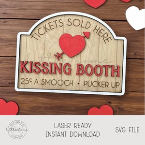 May include: A white sign with a red heart and arrow, reading "Tickets Sold Here" and "Kissing Booth 25¢ a smooch - pucker up".