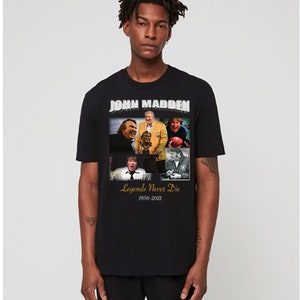 Könnte beinhalten: Schwarzes T-Shirt mit einer Collage von Fotos von John Madden, einem Football-Trainer und Kommentator. Der Text "John Madden" ist in Silber über der Collage gedruckt. Der Text "Legends Never Die" ist in Gold unter der Collage gedruckt, mit den Jahren "1936-2021" darunter.