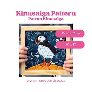 Può includere: Un progetto artigianale Kinusaiga con un design a forma di pulcinella di mare in una cornice di legno chiaro. L'opera misura 17cm x 17cm. La pulcinella di mare è realizzata con pezzi di tessuto neri, bianchi e arancioni su uno sfondo floreale.