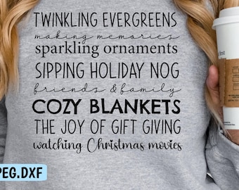 May include: A gray sweatshirt with the words "TWINKLING EVERGREENS, making memories, sparkling ornaments, SIPPING HOLIDAY NOG, friends & family, COZY BLANKETS, THE JOY OF GIFT GIVING, watching Christmas movies" printed in black. A white coffee cup is held in the hand.