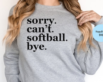 May include: A gray sweatshirt with the text "sorry. can't. softball. bye." in black lettering. The sweatshirt is being worn by a person with long blonde hair.