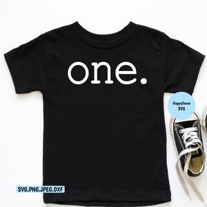 May include: Black toddler t-shirt with the word "one." printed in white. The shirt is paired with black and white sneakers with white laces. The design is simple and suitable for a first birthday celebration.