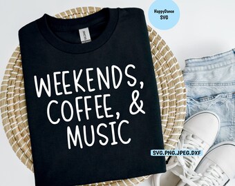 Könnte beinhalten: Schwarzes T-Shirt mit weißem Text, der "Weekends, Coffee, & Music" lautet. Das Shirt ist gefaltet und liegt auf einem geflochtenen Korb mit einem Paar weißen Sneakers und einer blauen Jeans-Shorts.