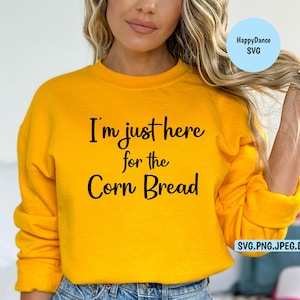 May include: A yellow sweatshirt with the text "I'm just here for the corn bread" printed on the front.