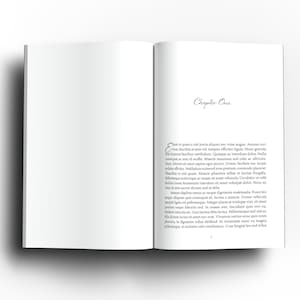 May include: An open book with white pages, displaying the text "Chapter One" in cursive. The right page contains body text in a serif font. The book is set against a white background, with a shadow.