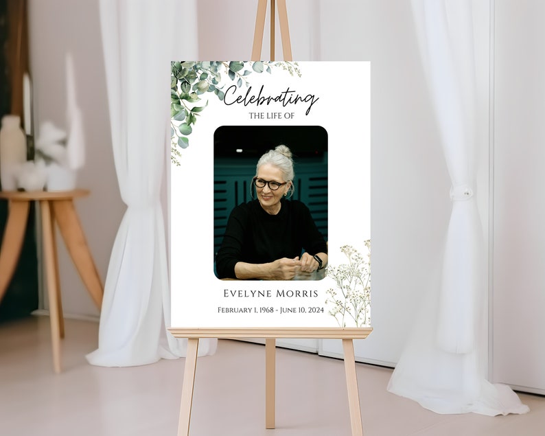 Pu&ograve; includere: Un poster commemorativo bianco con una foto di una donna, vegetazione verde e il testo "Celebrando la vita di Evelyne Morris, 1 febbraio 1968 - 10 giugno 2024".