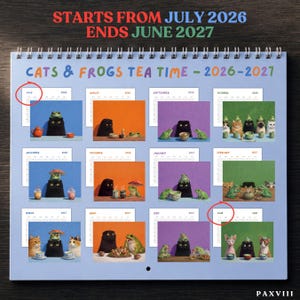 May include: A spiral-bound wall calendar titled Cats & Frogs Tea Time 2026-2027, featuring twelve monthly grid pages with illustrations of cats and frogs having tea. The text reads Starts From July 2026 Ends June 2027, with red circles highlighting July and June.