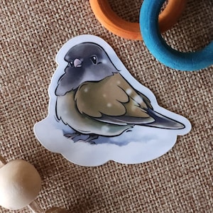 May include: A sticker featuring a cartoon illustration of a small, brown and gray bird with white spots on its feathers. The bird is standing on a snowy surface.