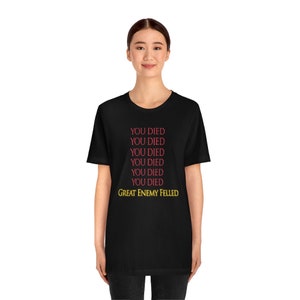 May include: Black t-shirt with the text "YOU DIED" repeated six times in red and "GREAT ENEMY FELLED" in yellow.