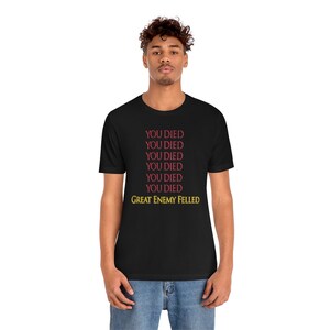 May include: Black t-shirt with the text "YOU DIED" repeated six times in red and "GREAT ENEMY FELLED" in yellow.
