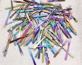 May include: A large pile of colourful, iridescent metal forks. The forks are all different lengths and have a variety of patterns.