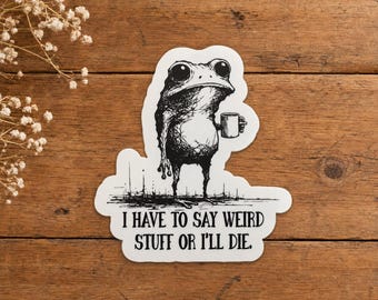 Pode incluir: Um adesivo recortado com uma ilustração em tinta preta e branca de um sapo segurando uma caneca pequena. Abaixo do sapo, o texto diz: I HAVE TO SAY WEIRD STUFF OR I'LL DIE. O adesivo tem uma borda branca e uma aparência de esboço.
