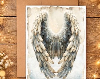 May include: A rectangular greeting card featuring a watercolor illustration of large, detailed angel wings in shades of grey, white, and beige. The wings are centered against a soft, cloudy background with subtle white speckles, presented with a brown envelope.