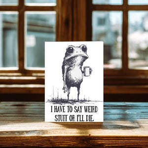 May include: A black and white illustration of a frog holding a mug. The frog has large eyes and a grumpy expression. The text "I HAVE TO SAY WEIRD STUFF OR I'LL DIE." is below the frog.