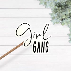 Può includere: Sticker bianco con testo nero che dice "Girl Gang".