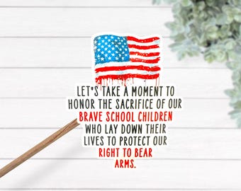 May include: A sticker featuring the American flag with red dripping paint. Text reads: "LET'S TAKE A MOMENT TO HONOR THE SACRIFICE OF OUR BRAVE SCHOOL CHILDREN WHO LAY DOWN THEIR LIVES TO PROTECT OUR RIGHT TO BEAR ARMS."