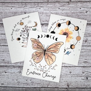 May include: Three printable cards with inspirational quotes and celestial imagery. The first card features a sun, moon, and planets with the text "Grow through what you go through". The second card features a butterfly with the text "Embrace Change". The third card features a sunflower and a moon cycle with the text "Always believe in magic".