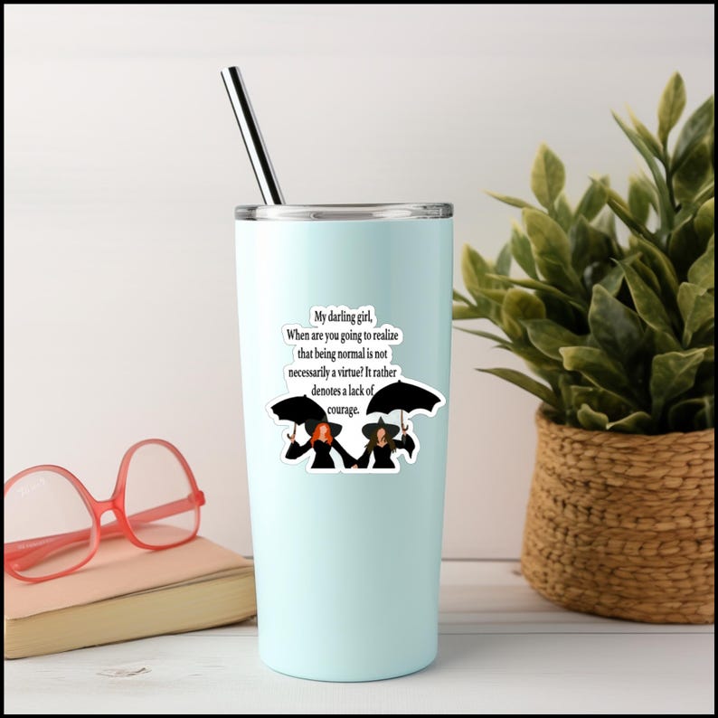 May include: A light blue tumbler with a white sticker featuring a quote about courage and two witches under umbrellas. The quote reads: "My darling girl, When are you going to realize that being normal is not necessarily a virtue? It rather denotes a lack of courage."
