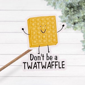 Può includere: Un adesivo bianco con un waffle di cartone animato con un viso sorridente e il testo "Don't be a TWATWAFFLE".