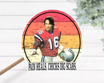 Può includere: Un adesivo in stile vintage con un giocatore di football americano che indossa una maglia rossa con il numero 16. Il giocatore sta tenendo un pallone da football e ha un'espressione determinata sul viso. L'adesivo ha uno sfondo color tramonto con un cerchio bianco attorno al giocatore. Il testo "PAIN HEALS, CHICKS DIG SCARS." è stampato sotto l'adesivo.
