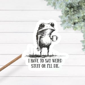 May include: A black and white sticker featuring a quirky frog holding a mug. The frog has large eyes and a slightly grumpy expression. The sticker includes the text: "I HAVE TO SAY WEIRD STUFF OR I'LL DIE."