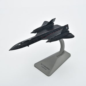 Puede incluir: Modelo de avión negro del SR-71 Blackbird sobre una base gris. La base tiene el texto "SR-71 Blackbird 1/200 Scale".