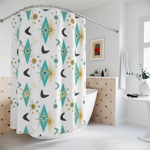 May include: A white shower curtain featuring a repeating pattern of teal and gold diamond shapes, starbursts, and dark gray boomerang motifs. The fabric hangs from a curved metal rod, displaying a consistent geometric design across the entire surface.
