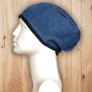 Op de afbeelding: Een blauwe denim scrub-muts met een zwarte rand. De muts wordt gedragen op een wit mannequinhoofd.